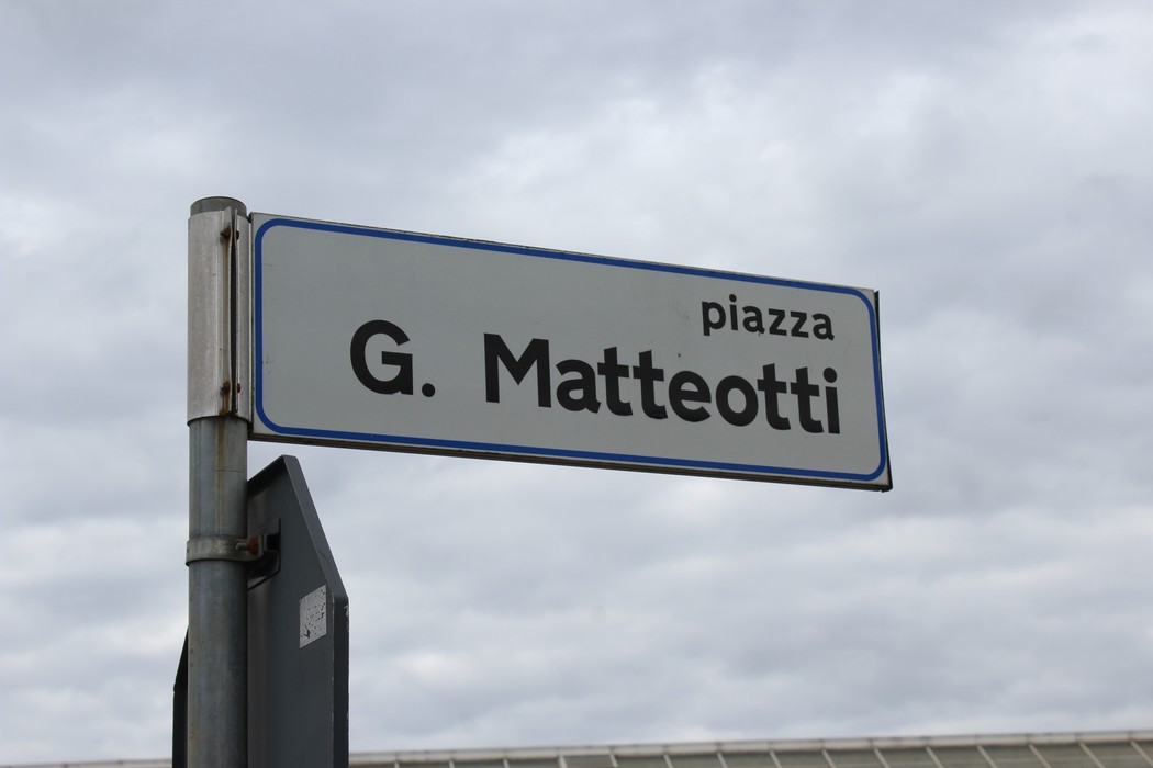 Targa stradale che indica piazza G. Matteotti con sfondo nuvoloso.