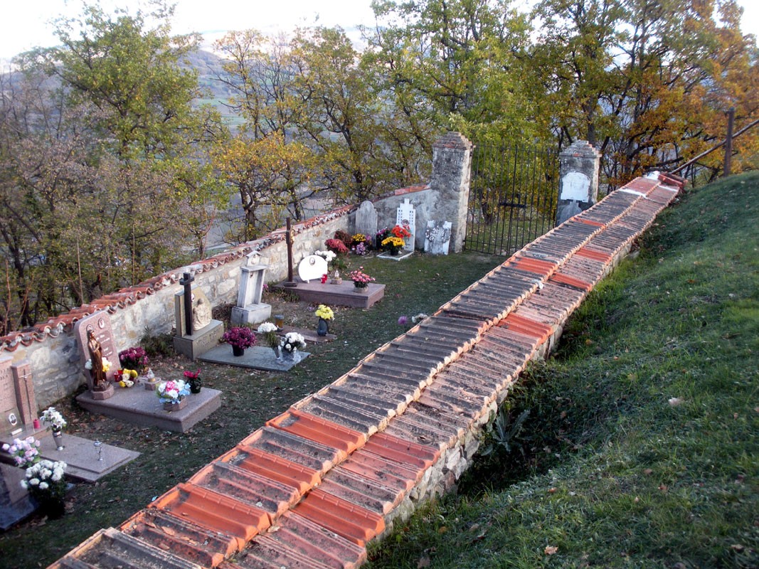 Lapide commemorativa di Esposito, Venagli e Zanonato in un cimitero circondato da un paesaggio naturale.