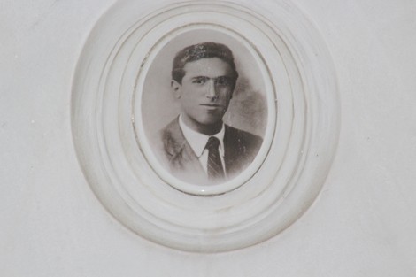 Ritratto in bianco e nero di un giovane uomo con giacca e cravatta, incorniciato in un ovalo bianco.