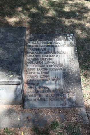 Monumento ai Martiri del Panaro, incisi nomi in memoria dei caduti, situato in un'area verde.