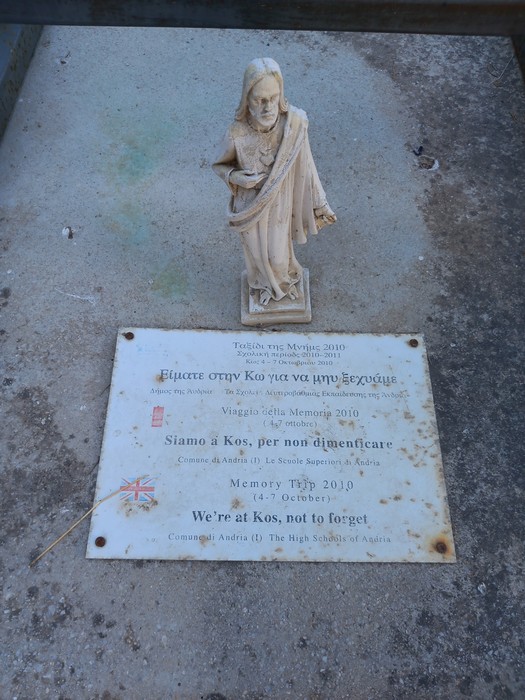 Una statua commemorativa e una targa al "Sacrario dei caduti di Kos", simbolo di memoria e rispetto.