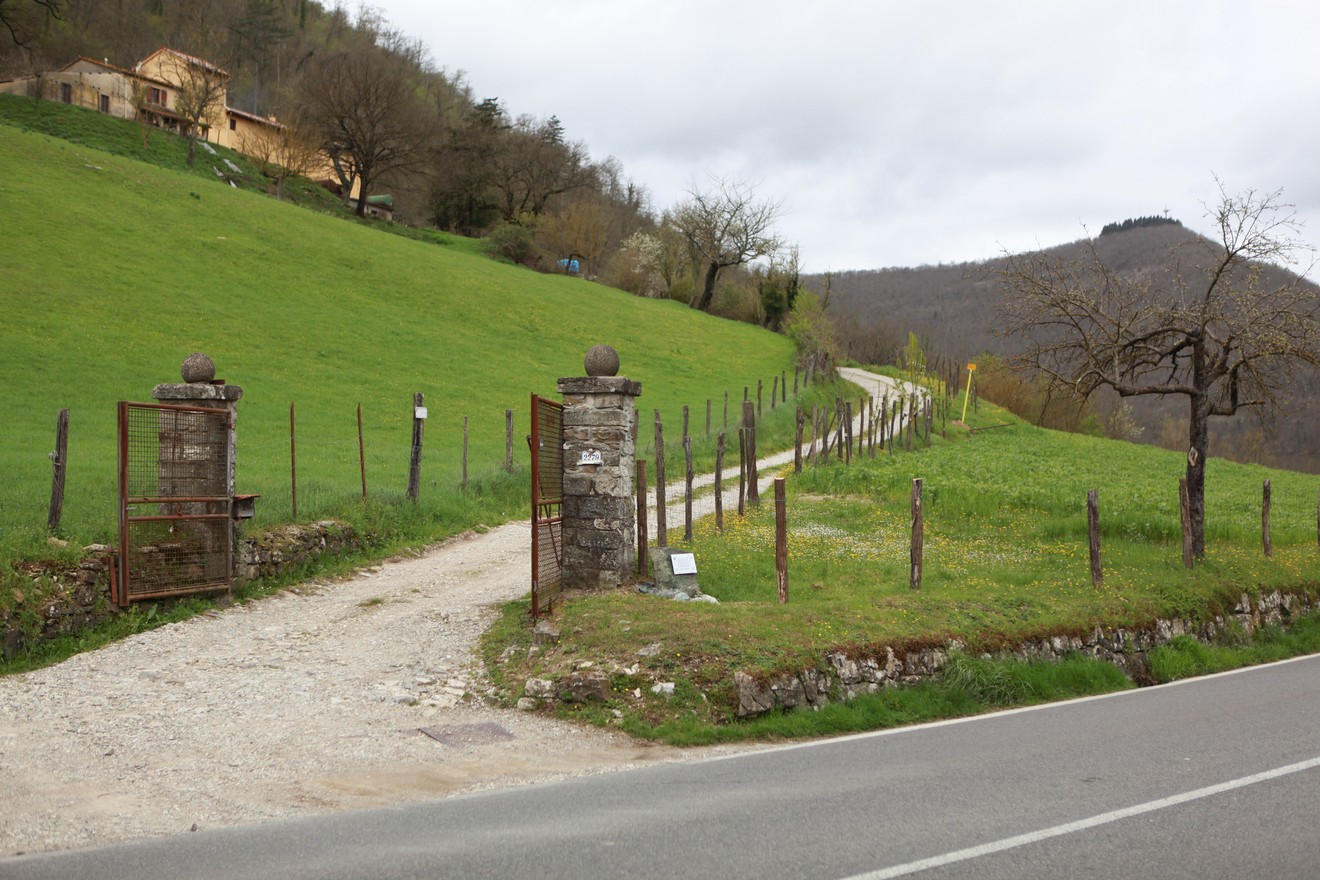 Cippo commemorativo della battaglia della brigata Storai in un paesaggio collinare.