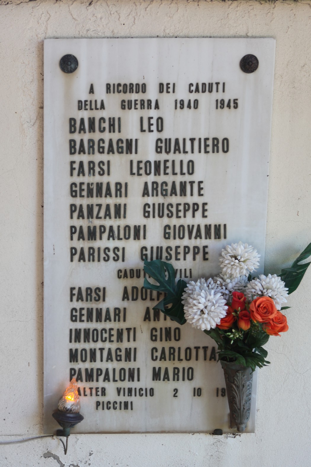 Lapide commemorativa alle vittime civili di Corella, con nomi e fiori in omaggio.
