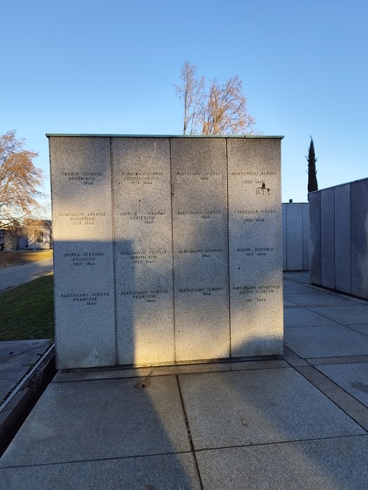 Monumento commemorativo con lastre di pietra incise e luce del sole che crea ombre, rappresentante il "Campo della Gloria".