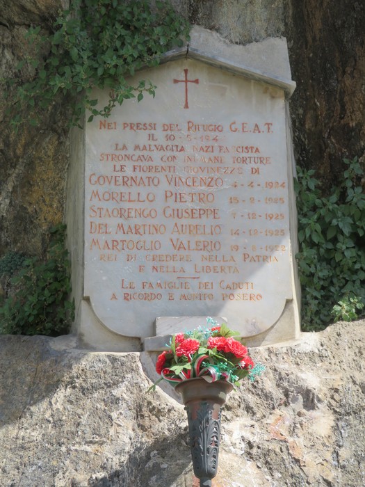 Cippi commemorativi ai caduti del rifugio GEAT e della Brigata Carli, con un omaggio floreale.