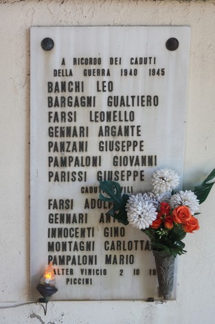 Lapide commemorativa alle vittime civili di Corella, con nomi e fiori in omaggio.