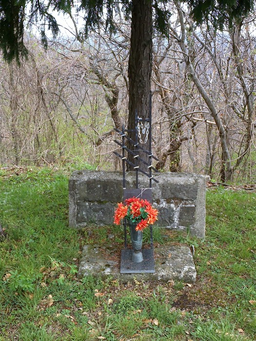 Cippo commemorativo con fiori, immerso nella natura, presso Ceccardi.