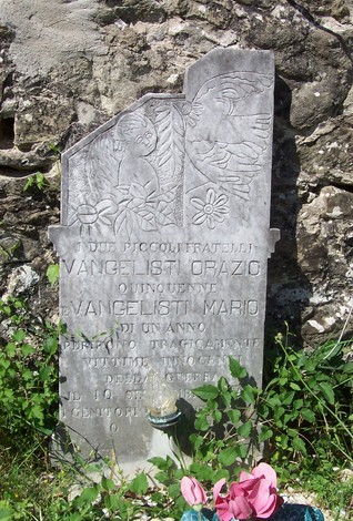 Sepolcro dei fratelli Orazio e Mario, con incisioni decorative e fiori ai piedi della lapide.