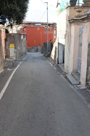 Una strada tranquilla con edifici e pietre d'inciampo dedicati alla famiglia Milani a Sonnino.