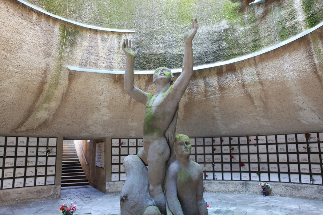 Monumento Ossario dei caduti partigiani, con statue e un'architettura che evoca emozione e memoria storica.