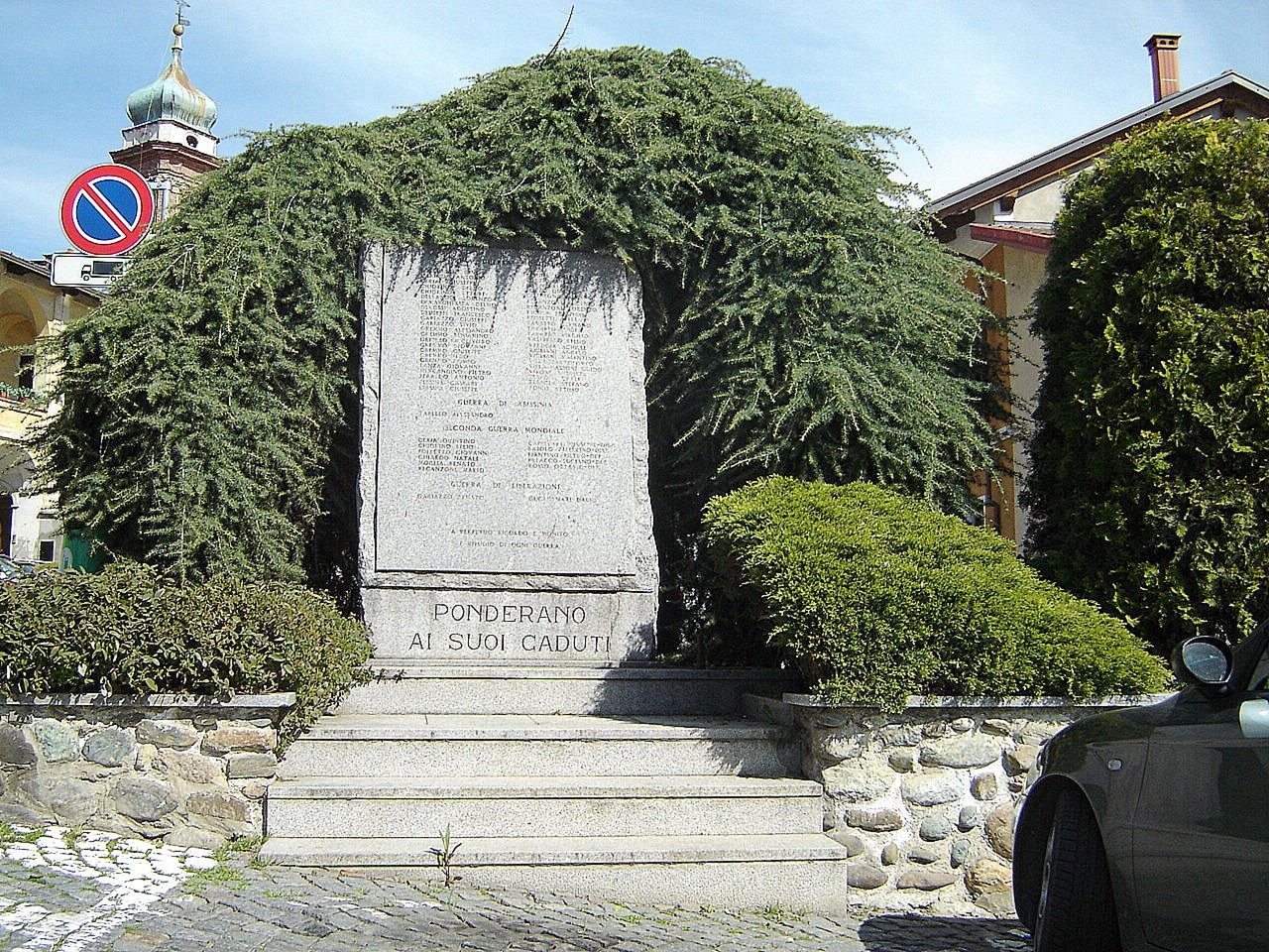 Monumento ai caduti di Ponderano, immerso nel verde con una struttura in pietra e scalinate.