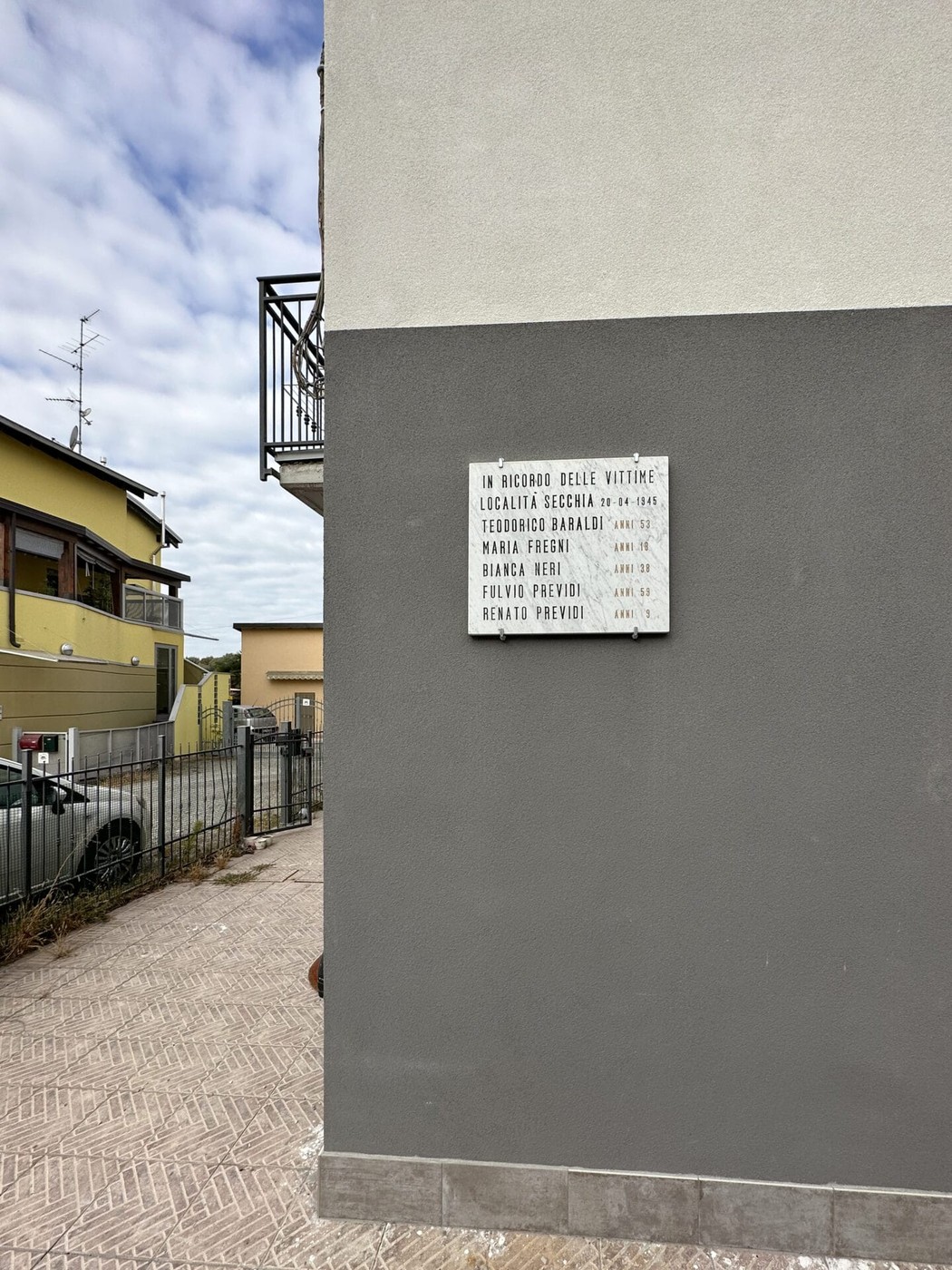 Lapide commemorativa ai caduti di Secchia, con nomi e date in memoria delle vittime della guerra.