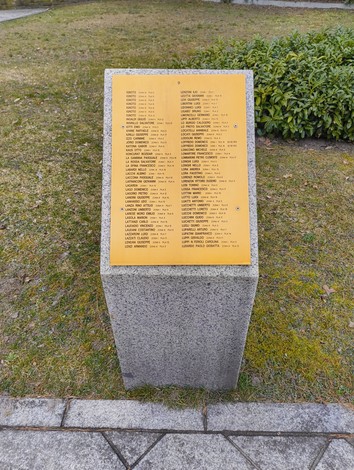 Cimitero militare italiano di Zehlendorf, monumento commemorativo con elenchi di nomi. Atmosfera di quiete e rispetto.