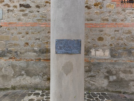 Colonna dedicata alla chiesa di Santa Maria Visitante, con base in pietra e iscrizioni commemorative.