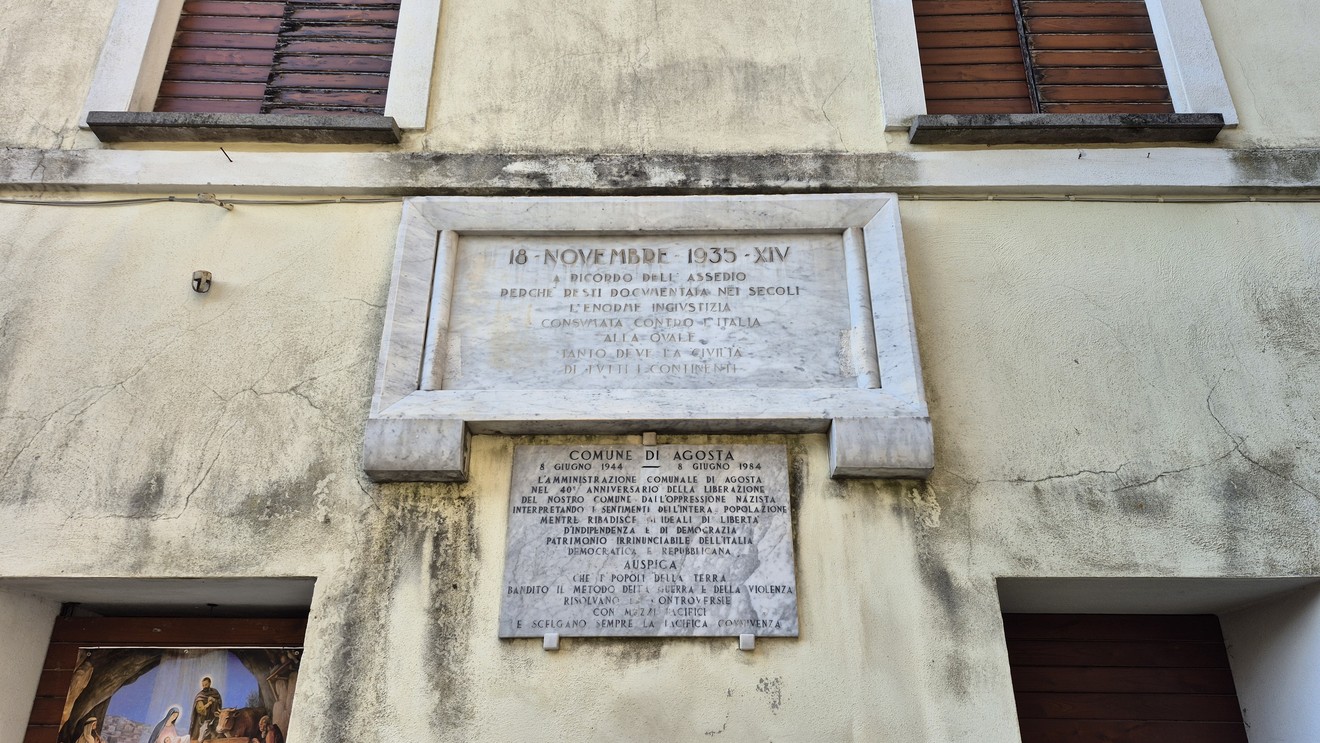 Lapide commemorativa per il 40° anniversario della Liberazione, situata su un edificio storico.