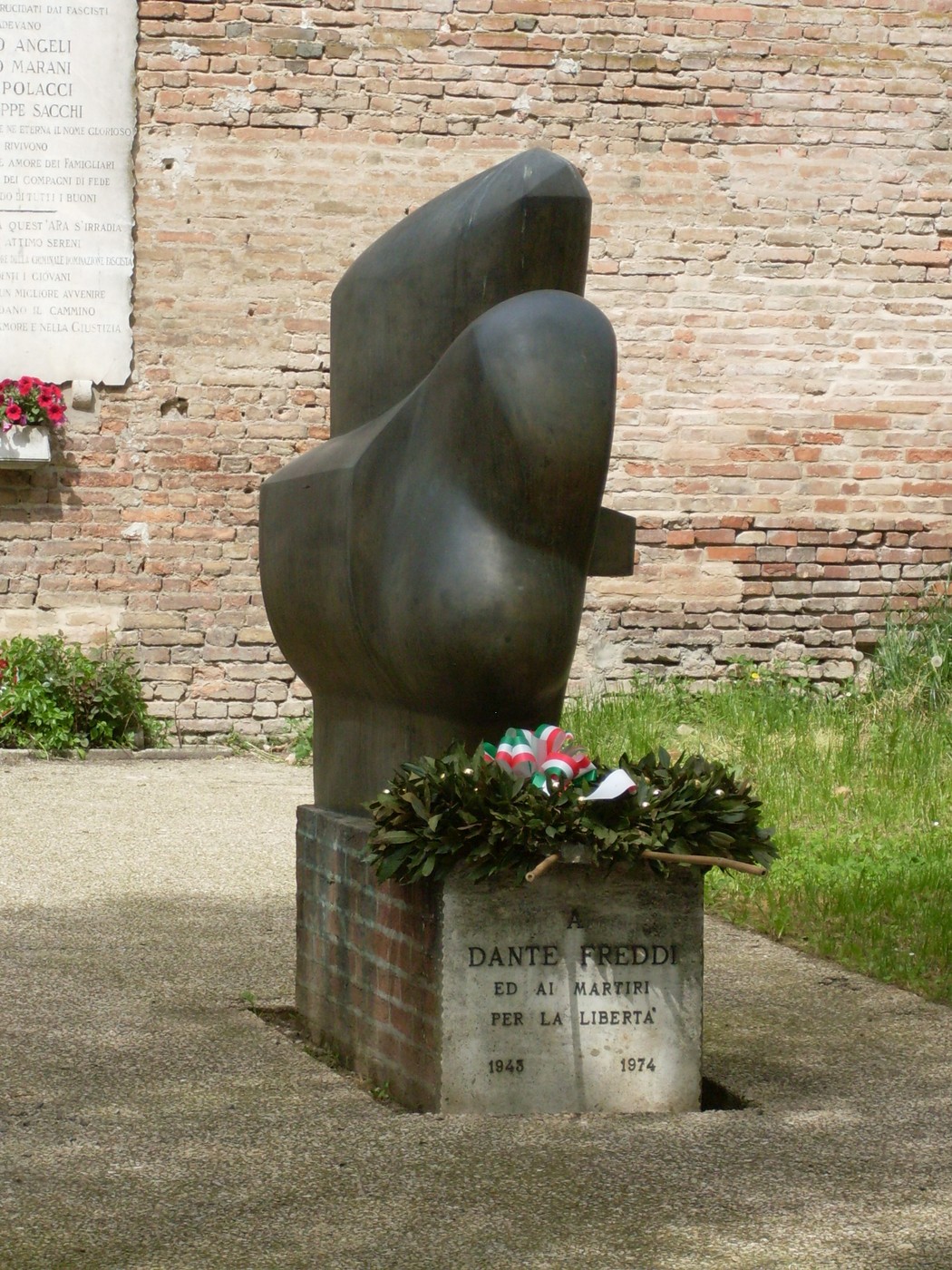 Monumento in bronzo dedicato a Dante Freddi e ai martiri per la libertà, allestito in un giardino pubblico.