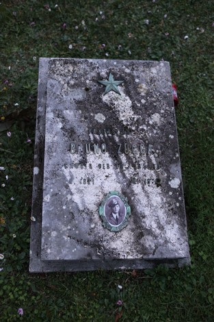 Tomba commemorativa di un partigiano, Sacrario dei partigiani pratesi, con elementi decorativi e flora circostante.