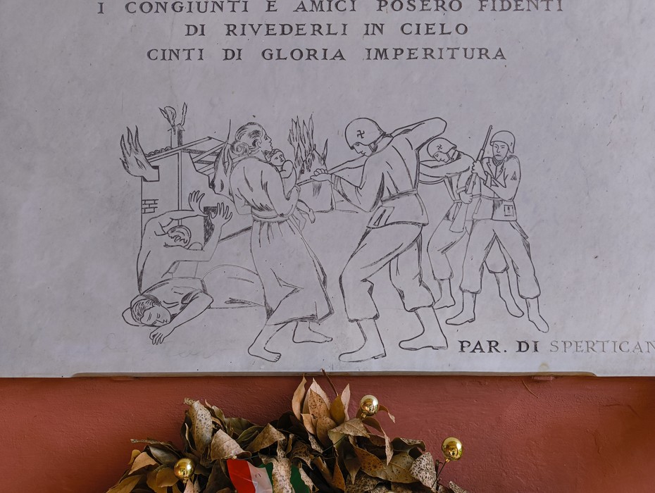 Lapidi commemorative per le vittime di Sperticano, con incisioni e omaggi floreali.