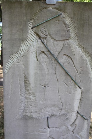 Monumento ai Martiri del Panaro, con incisioni che rappresentano figure umane in memoria dei caduti.