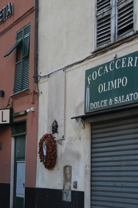 Lapide commemorativa dedicata ai caduti per la libertà, collocata su una parete esterna.
