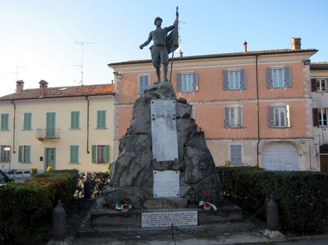 Monumento ai caduti di Rovescala, un tributo ai valorosi della comunità, circondato da verde e edifici storici.