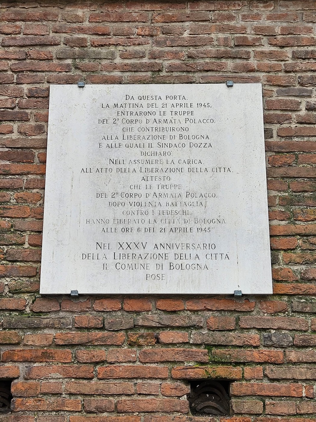 Lastra commemorativa del 2° Corpo d'Armata Polacco per la liberazione di Bologna, situata su un muro di mattoni.