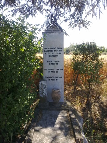Cippo commemorativo dedicato alle vittime dei fascisti a Davoli e ai Soliani, immerso nella natura circostante.