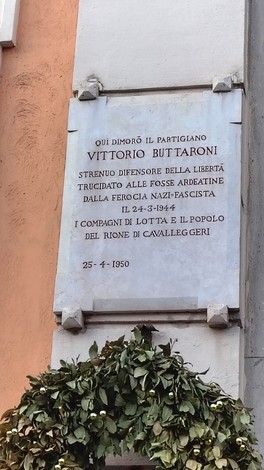 Lapide commemorativa dedicata al partigiano Vittorio Buttaroni, situata in un contesto urbano.