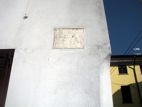 Lapide commemorativa dedicata a Fugazza Mario su un muro bianco.