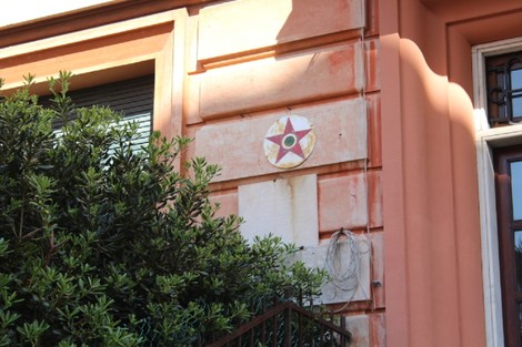 Lapide a Gaggero affissa a un muro, decorata con una stella a cinque punte su sfondo chiaro.