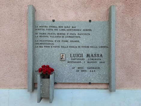 Lapide commemorativa a Massa con omaggio floreale, dedicata a Luigi Massa, partigiano e comunista.
