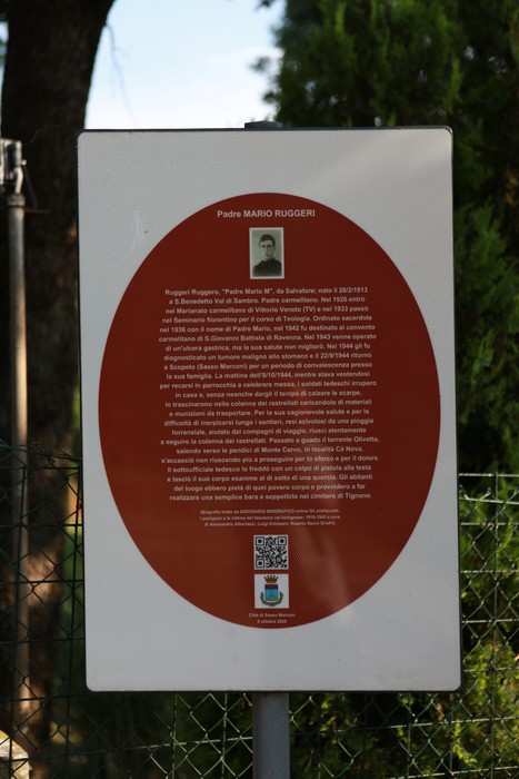 Cippo commemorativo dedicato a Padre Mario Ruggeri, con informazioni sulla sua vita e opera.
