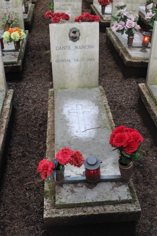 Tombe decorate con fiori e candele, dedicate ai caduti per la Libertà, in un cimitero.