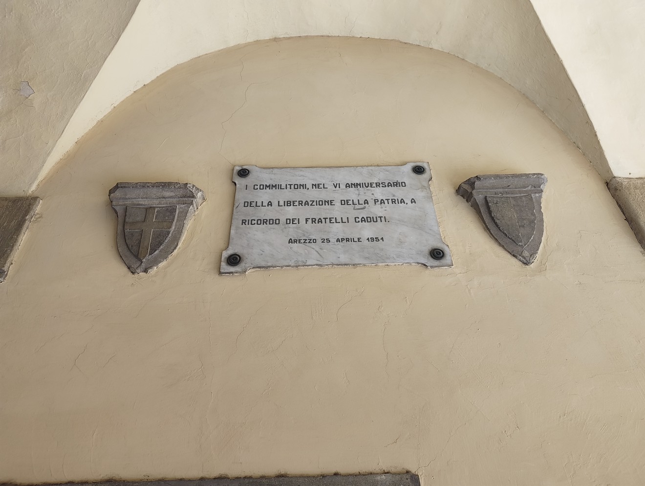 Lapide commemorativa ai caduti della Liberazione, con stemmi e dedica in memoria dei frati caduti.
