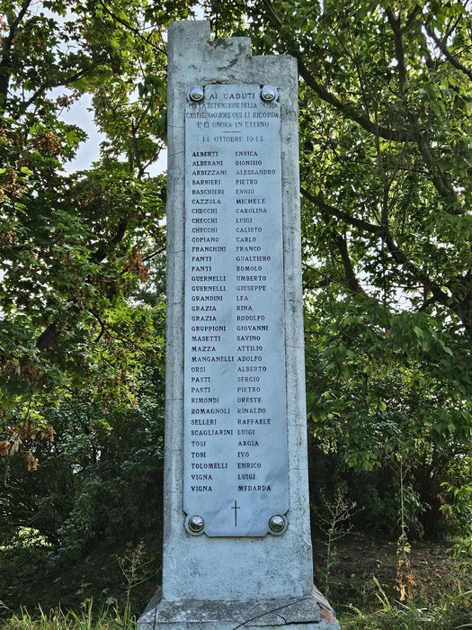 Monumento ai Martiri di Sabbiuno, commemorazione dei caduti con elenco di nomi su un pilastro di pietra.