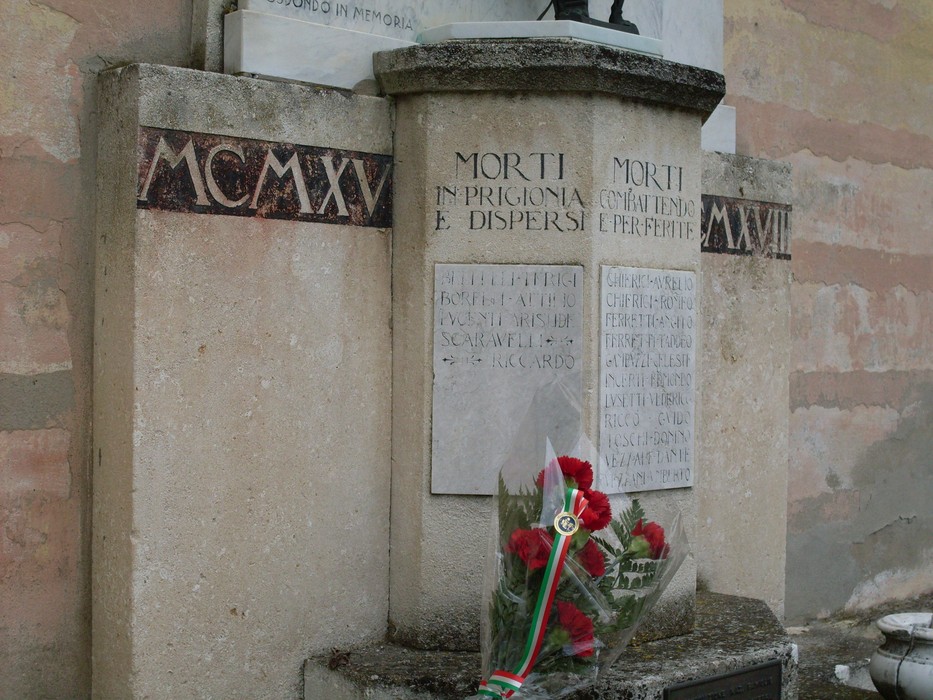 Lapide commemorativa ai caduti di Fosdondo, dedicata ai morti in guerra e dispersi, con decorazioni floreali.