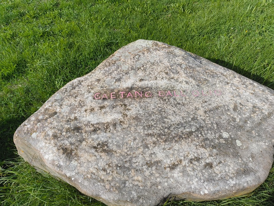 Monumento in memoria dei partigiani caduti, situato a Monte Sabbiuno, circondato da vegetazione.