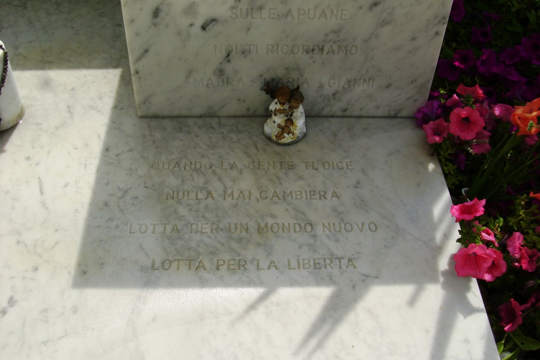 Sepolcro di Del Giudice, con monumento in marmo e fiori colorati. Un tributo alla memoria e alla libertà.