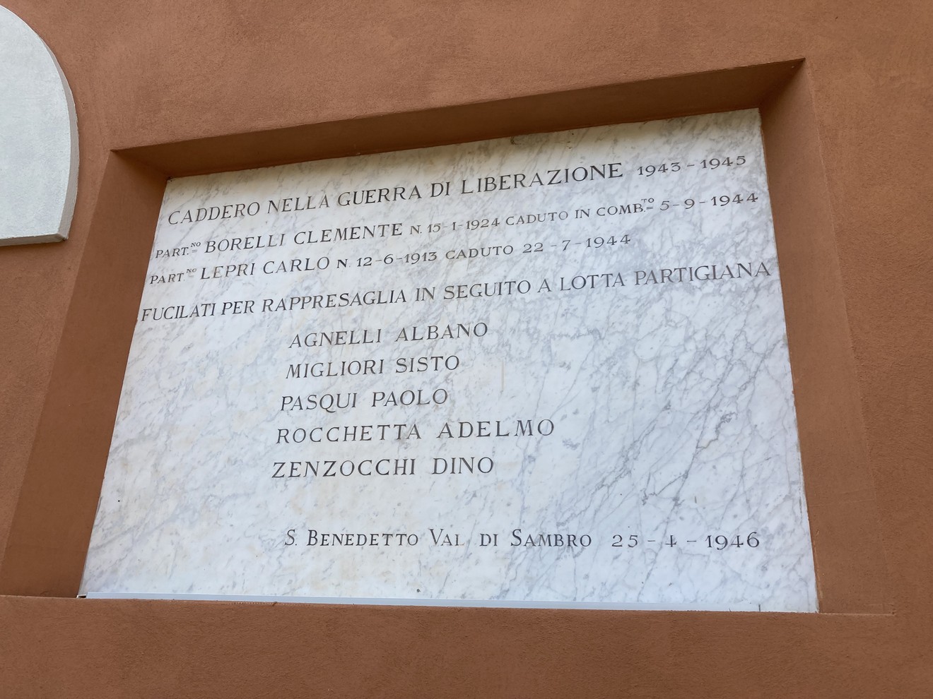 Lapide commemorativa dedicata ai caduti per la libertà, con nomi incisi e una significativa dedica.