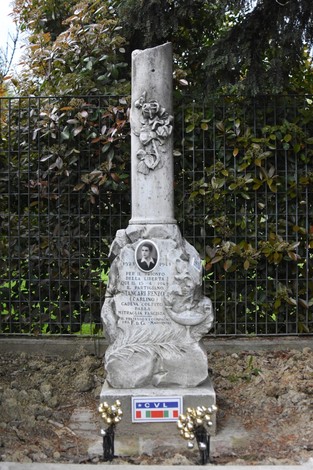 Cippo commemorativo a Stancari, dedicato alla memoria di un caduto, con decorazioni e simboli patriottici.