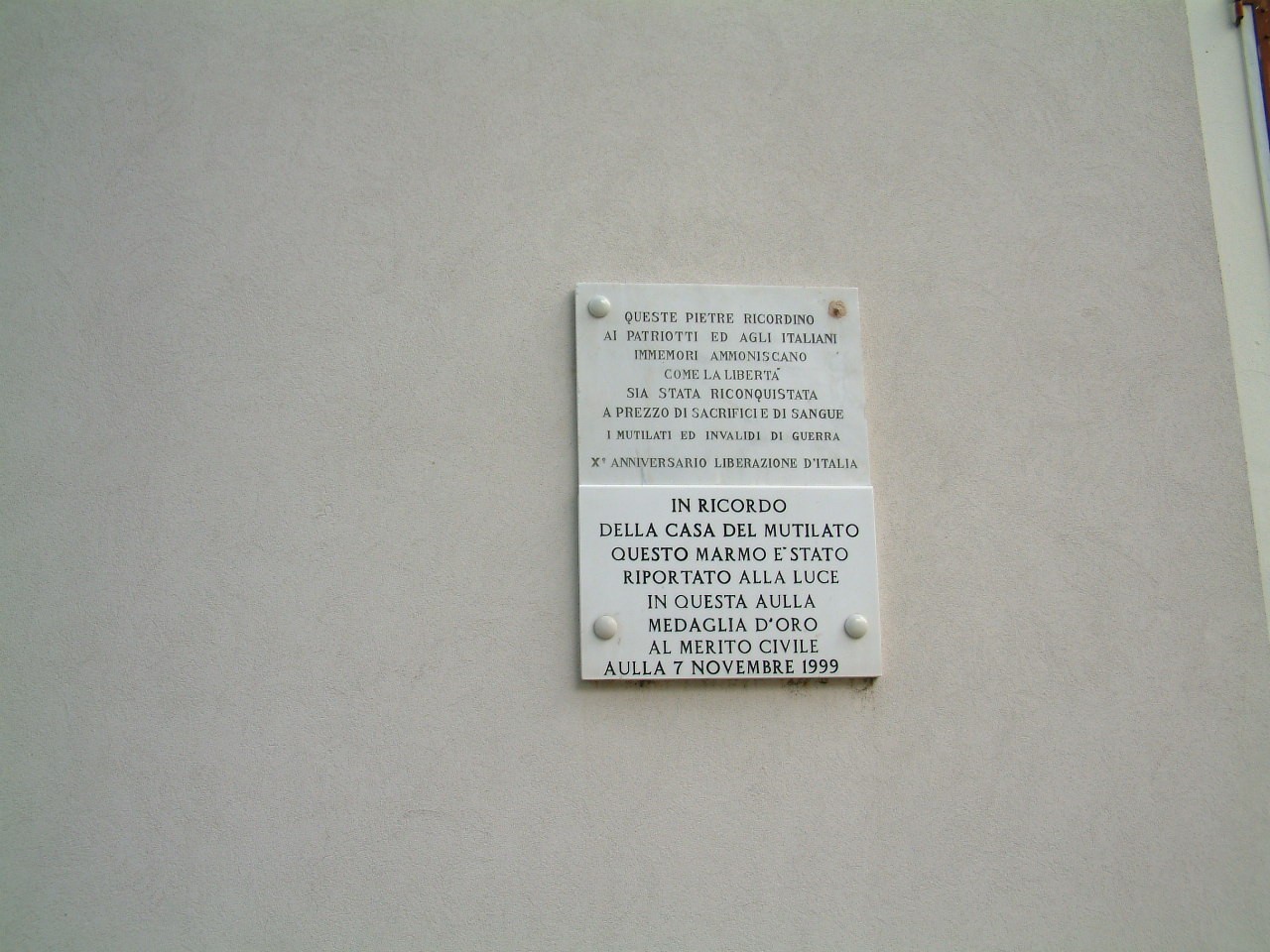 Lapide commemorativa della Casa del Mutilato, in ricordo dei sacrifici e delle sofferenze dei veterani.