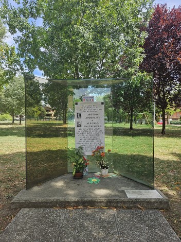 Monumento ad Anderlini e Paltrinieri, situato in un parco, con piante e fiori attorno.