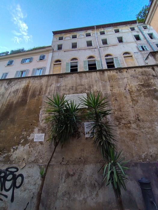 Lapide commemorativa che ricorda il genocidio dei nomadi, affissa su un muro di un edificio storico.
