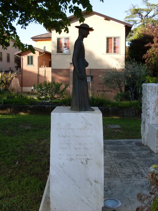 Monumento a Borghi, una scultura che celebra la memoria e la cultura del luogo, immersa in un verde paesaggio.