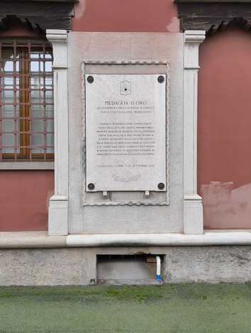Lapide commemorativa dedicata alla medaglia d'oro della Guardia di Finanza su un muro.