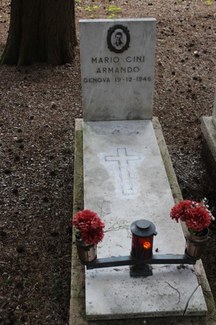 Tombe perpetue dei caduti per la Libertà, con fiori rossi e una lanternina accesa in un'atmosfera di reverente commemorazione.