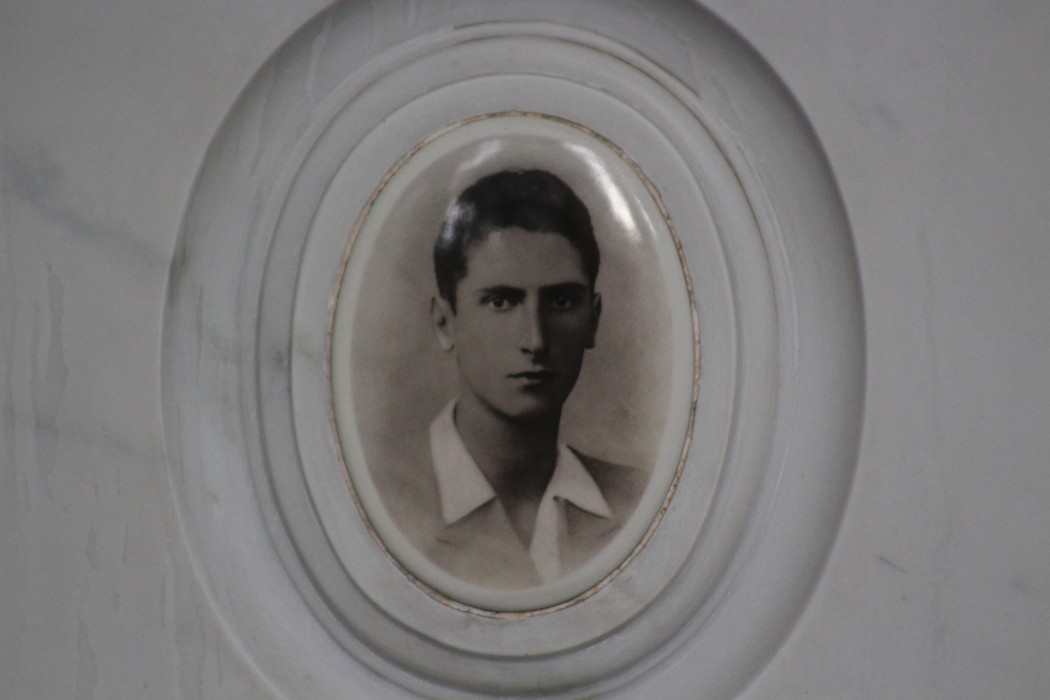 Ritratto in bianco e nero di un giovane uomo all'interno di un ovale, parte del "Sacrario dei partigiani di Torbella".