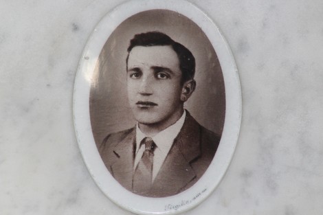 Ritratto di un giovane uomo in bianco e nero, incorniciato in una targa commemorativa del Sacrario dei caduti.