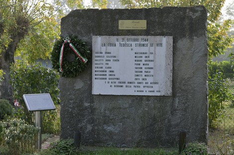 Monumento commemorativo con lapide dedicata alle vittime della Strage di Vigorso, decorato con una corona d'alloro.