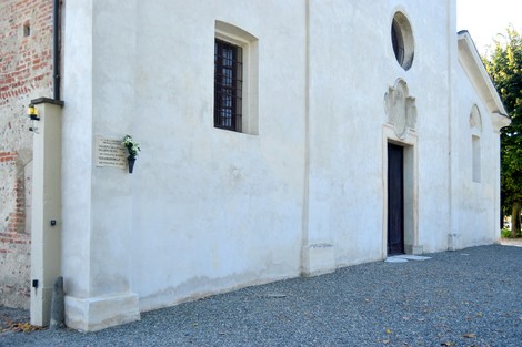 Lapide commemorativa ai Pagliero e a Tuscano su un edificio semplice, circondata da un ambiente naturale e curato.